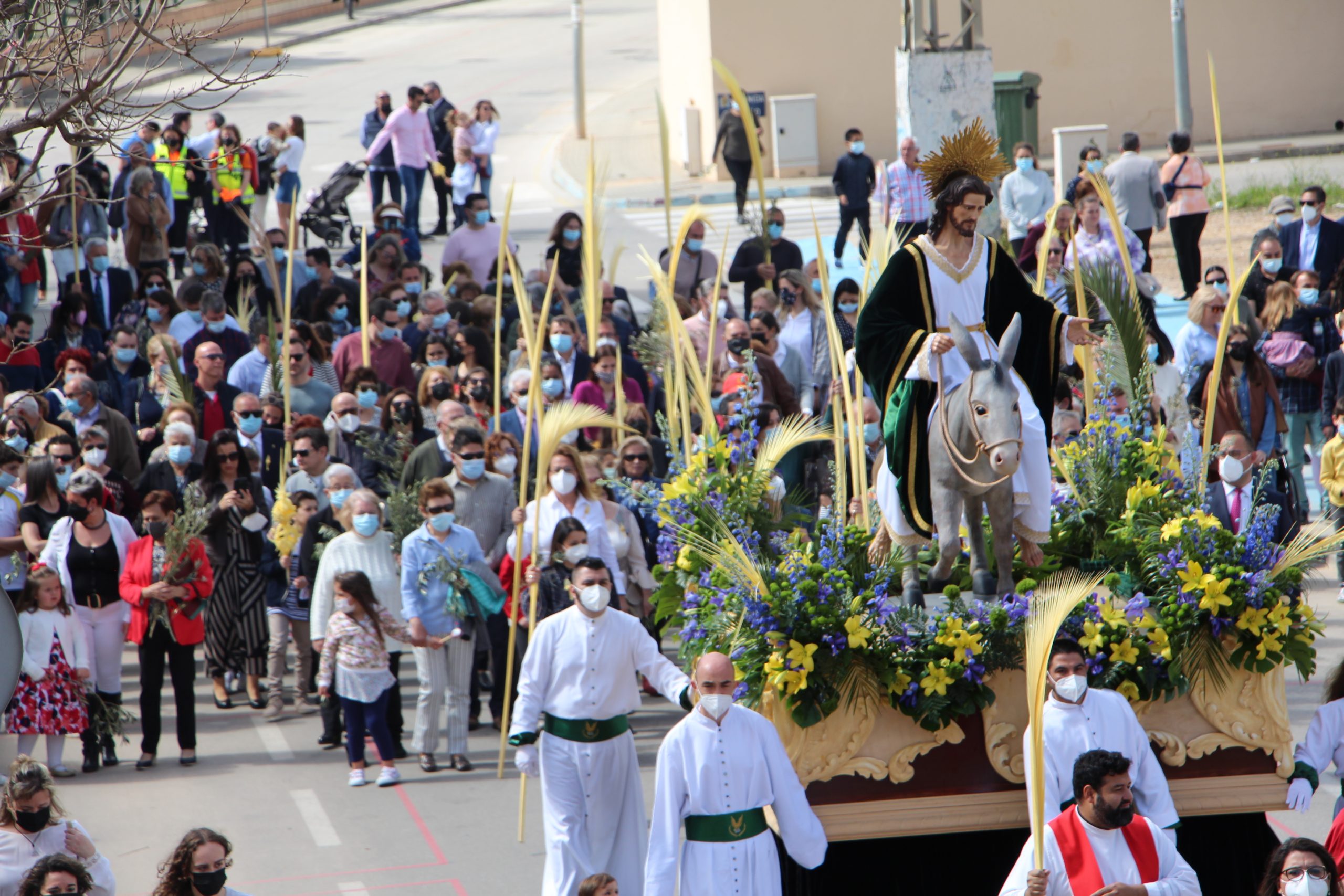 Palmas y ramas de olivo acompañan a Jesús Triunfante en la procesión de Domingo de Ramos